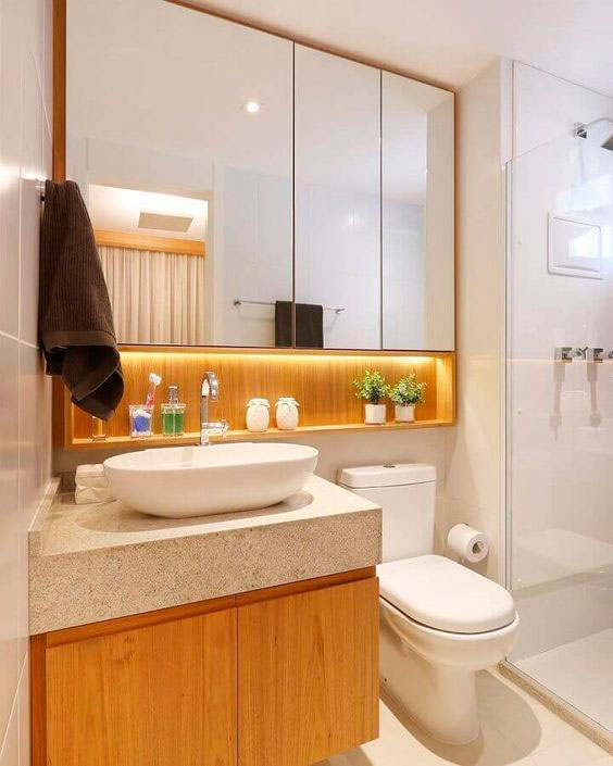 Banheiro de apartamento pequeno com armário espelhado